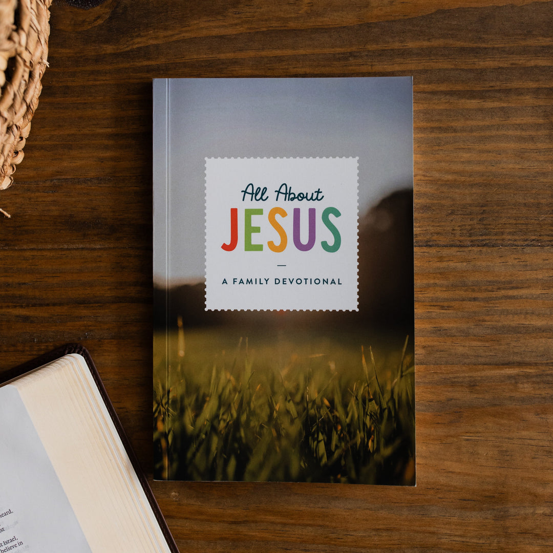 Book titled 'All About Jesus' on a wooden surface with a blurred background