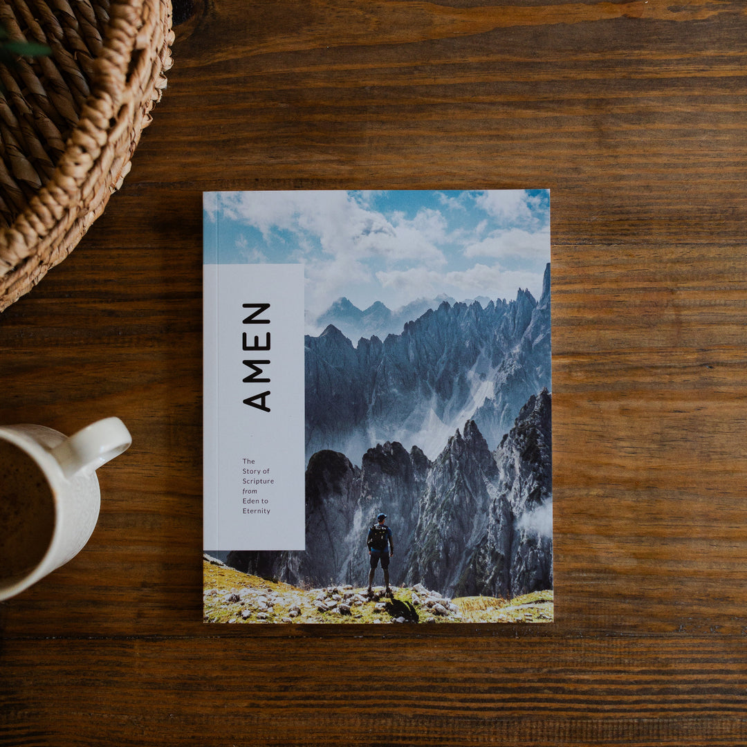 Amen Mens Study cover laying on a wooden table next to a white coffee cup and a woven basket