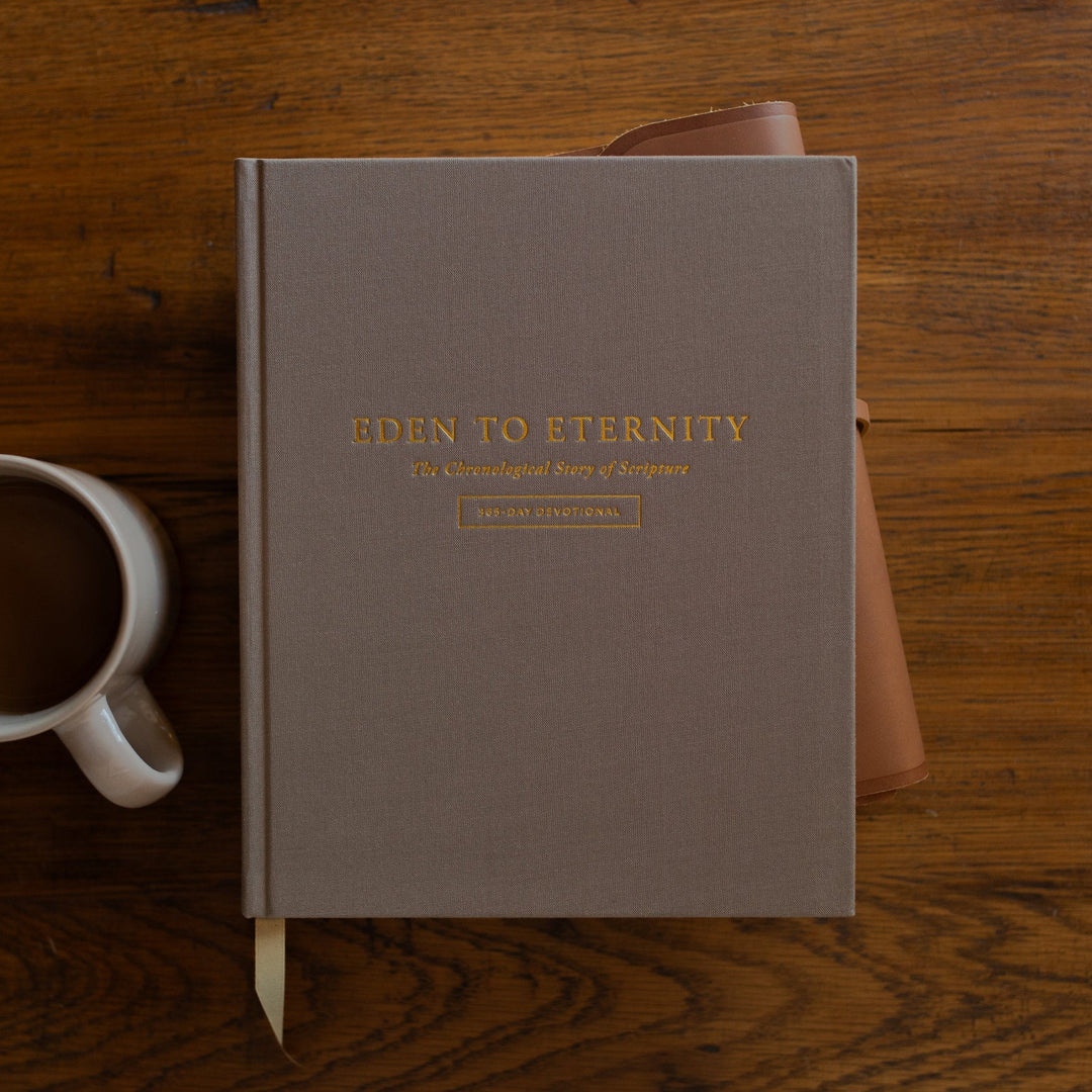 Eden to Eternity Devo cover on a leather wrapped bible next to a coffee cup on a wooden table