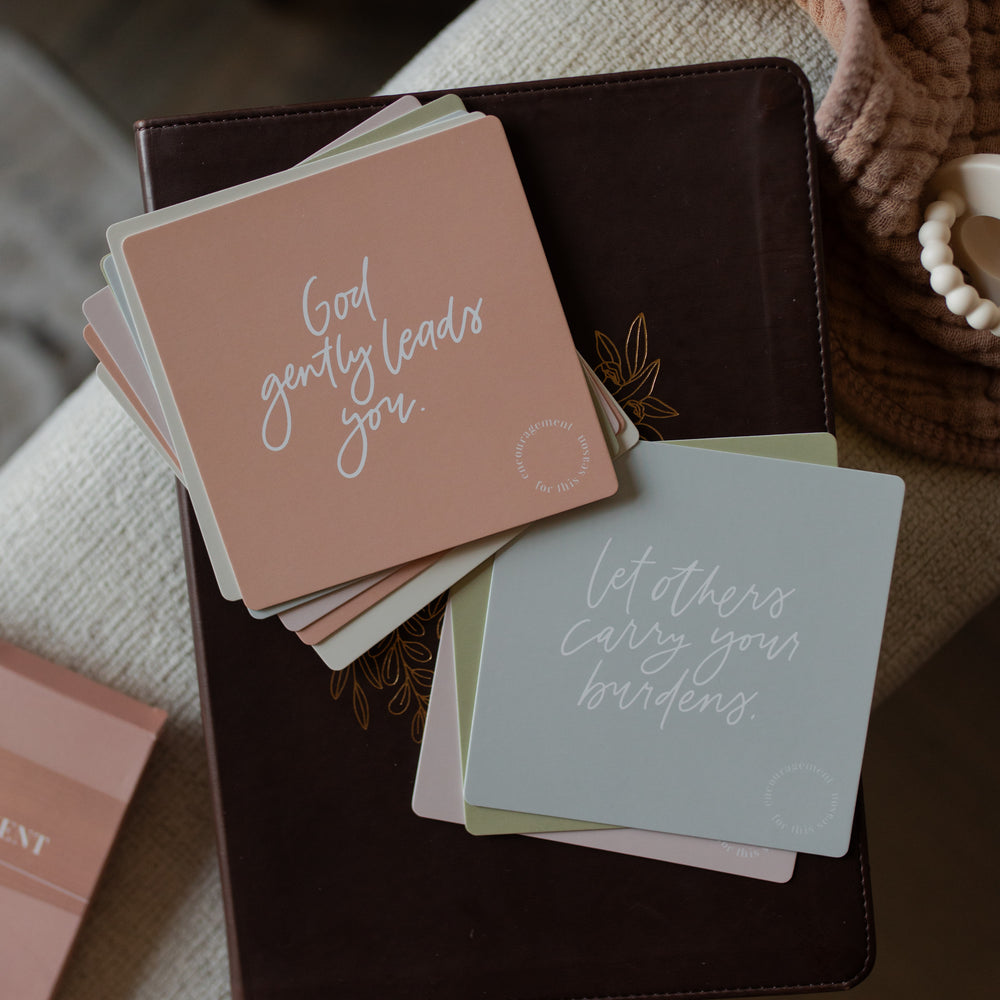 Stack of cards with motivational phrases on a textured surface