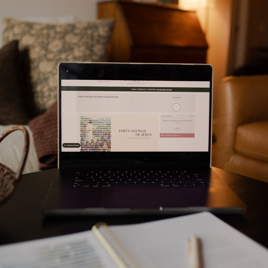 Laptop on a table opened to the Forty Sayings of Jesus Group Leader Guide Course in a cozy living room setting