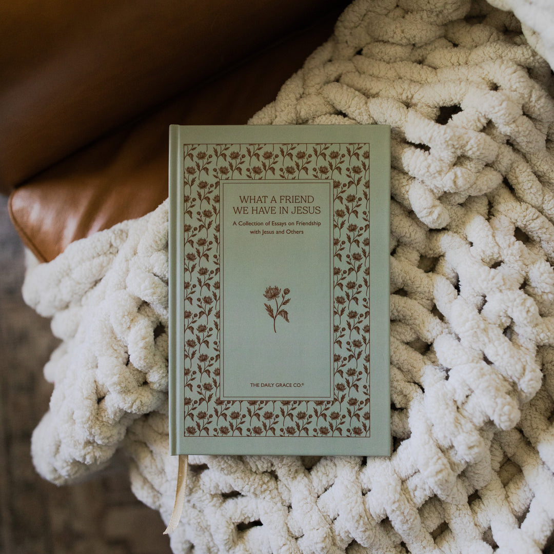 What a friend we have in Jesus cover on a white knitted blanket on a leather couch