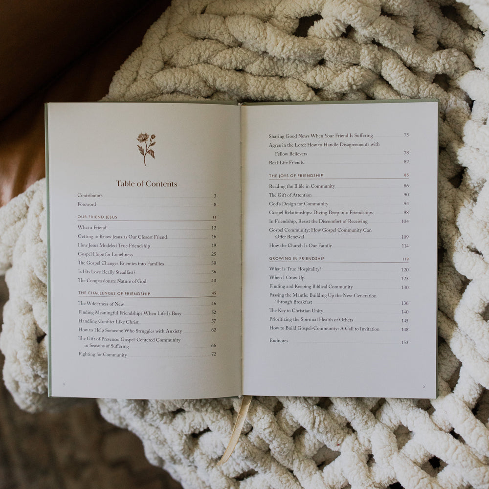 What a friend we have in Jesus opened to the Table of Contents page on a white knitted blanket on a leather couch