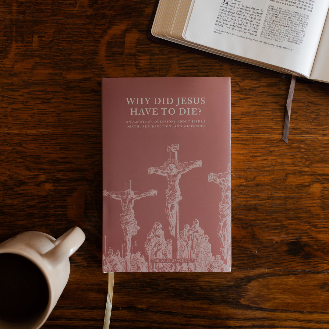 Why Did Jesus Have To Die cover on a wooden table next to an open bible and a coffee cup